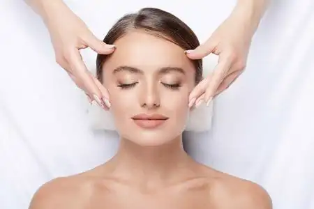 按摩肌肤拥有完美肌肤的年轻女子面部按摩, 手上的脸, 皮肤护理, 水疗