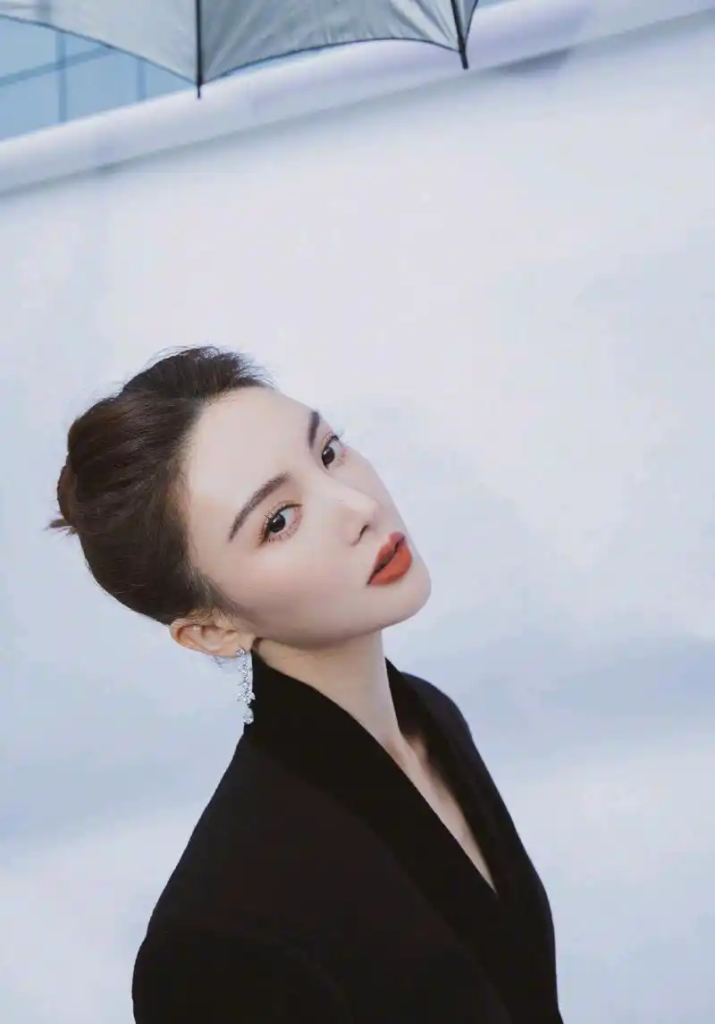 金晨身穿黑色西服套装,盘发造型干练飒爽,享受休闲自在