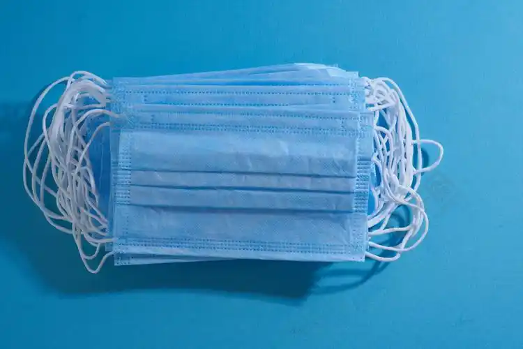 预防冠状病毒医用口罩 蓝色背景上的医用防护口罩一次性外科口罩覆盖