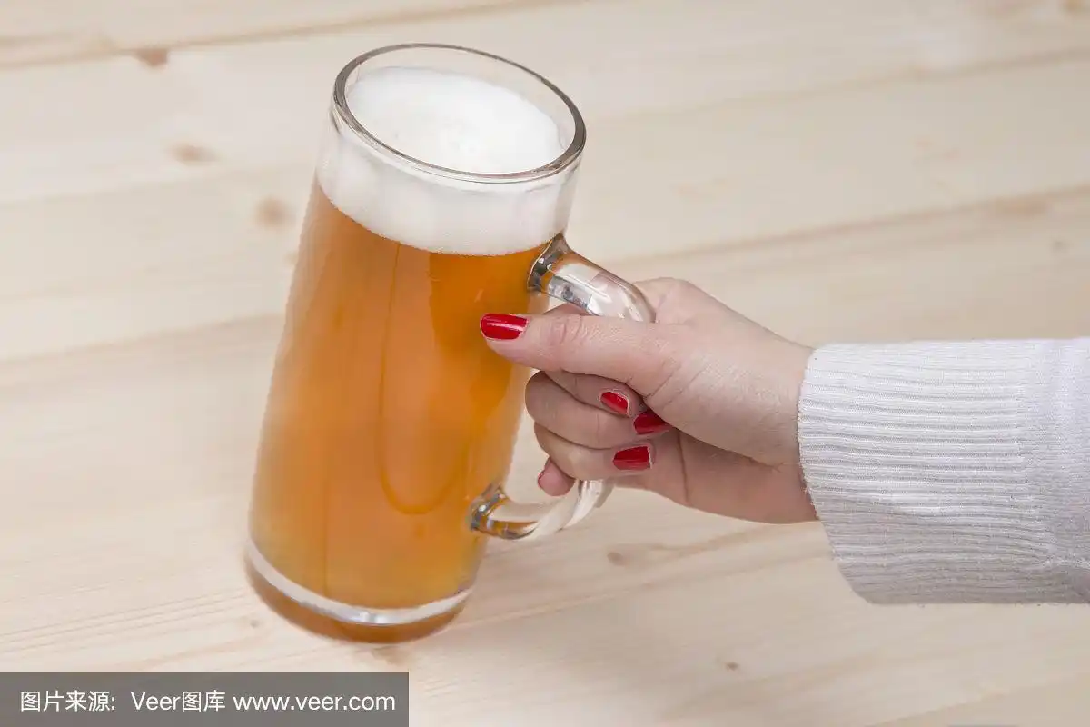 女士手里拿着一大杯生啤酒