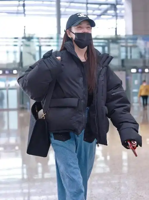张雨绮上海机场街拍黑色羽绒服配蓝色牛仔裤演绎低调美丽穿搭
