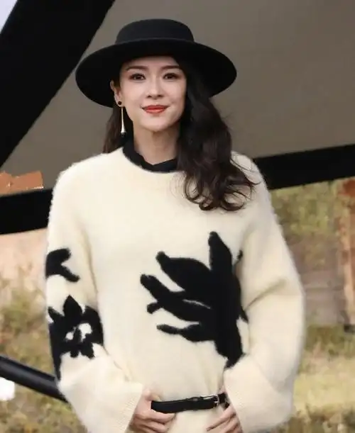 章子怡头戴黑色的礼帽,还留着漂亮的大波浪卷长发,染着红色的嘴唇,真