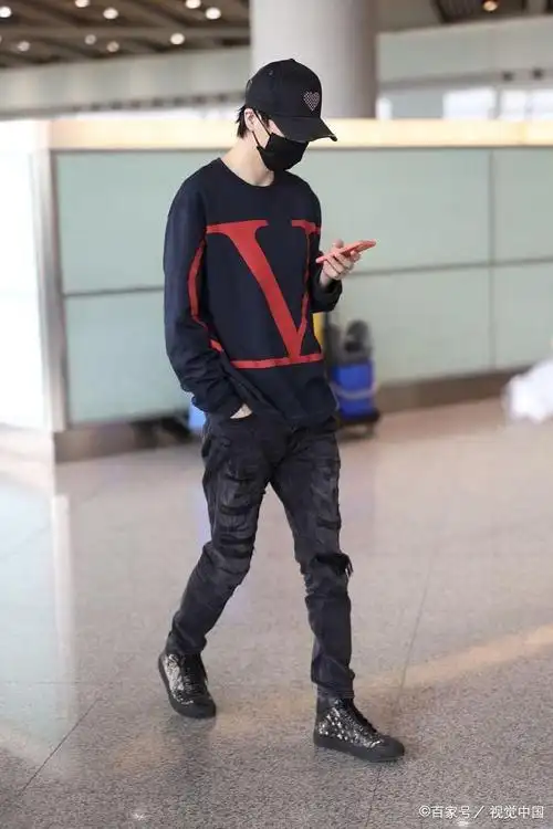 许嵩穿深蓝色卫衣亮相机场 棒球帽上红桃心可爱抢眼