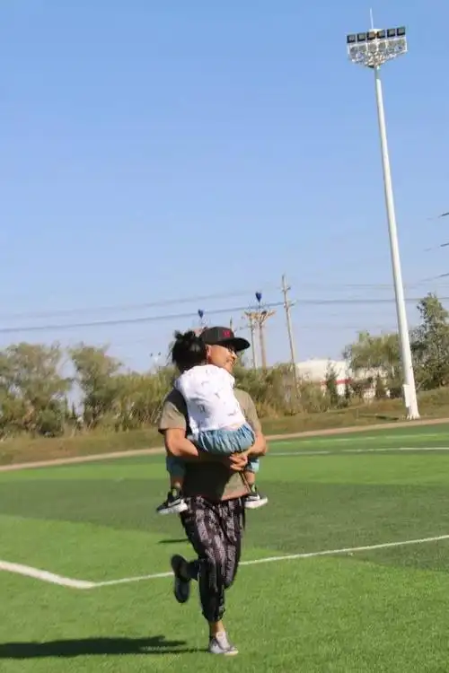 迅速奔向终点,孩子抱紧爸爸的脖子,双腿紧紧夹在爸爸的腰上,就像一