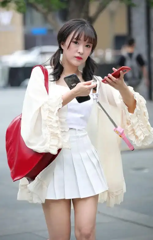 时尚小姐姐百褶短裙大秀美腿,可爱的双马尾垂在肩膀上,清纯妩媚