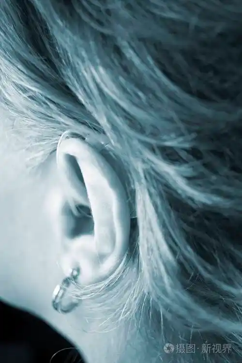 聋人女士她的耳朵里有现代技术数字助听器