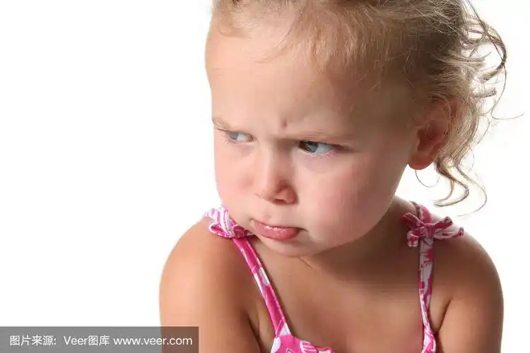 愤怒的蹒跚学步的女孩在白色背景下撅嘴