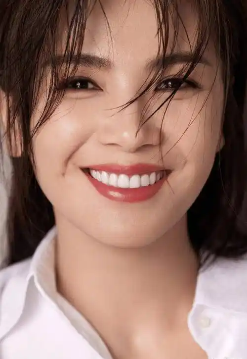 照片中,刘涛身穿白色衬衫,头发披散在肩,对着镜头露出一抹灿