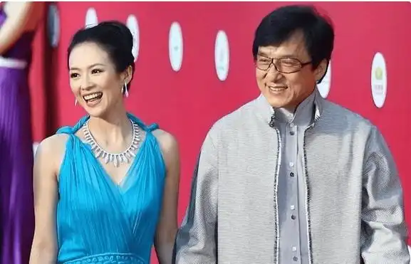 章子怡镇定自若地走向成龙,脸上挂着灿烂的笑容.