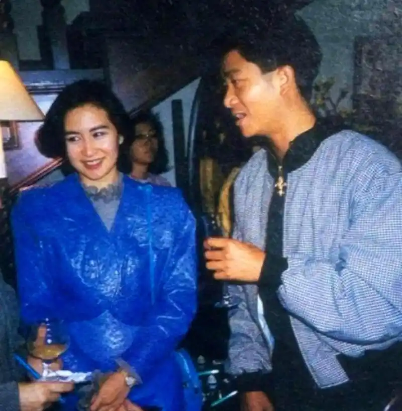 何超琼和好友陈百强合影,她穿着蓝色礼服,显得非常亮眼.