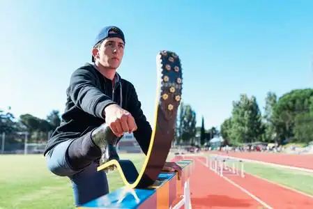 残疾的男子运动员伸展腿假肢照片