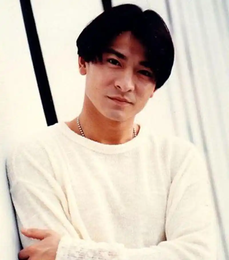 这一位留着中分发型,穿着白色上衣,看起来非常年轻帅气的帅哥是刘德华