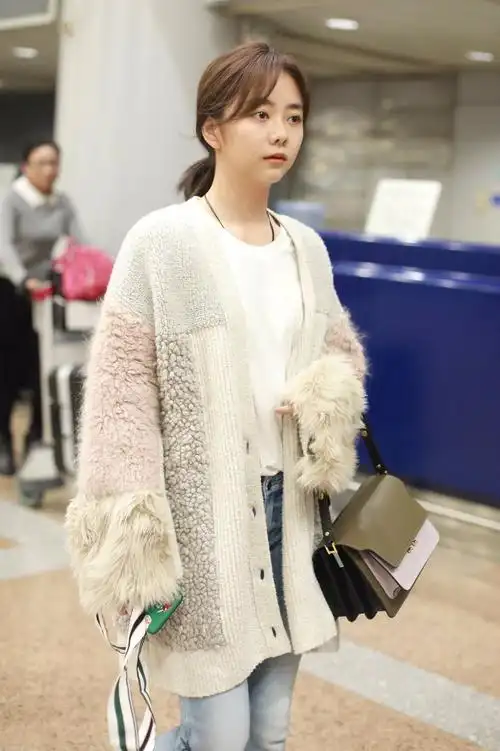 谭松韵穿开衫毛衣搭配蓝色牛仔裤现身机场,皮肤白皙面带微笑