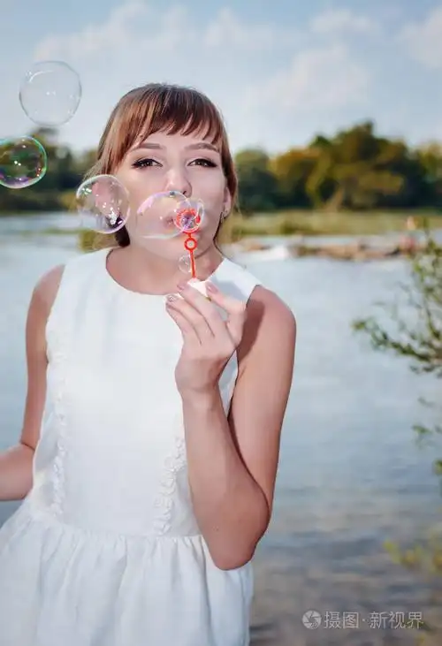 年轻漂亮的新婚新娘吹肥皂泡沫