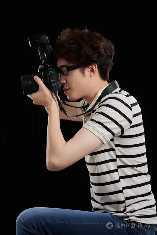 年轻摄影师的侧面图忙于工作照片-正版商用图片06ca9o-摄图新视界