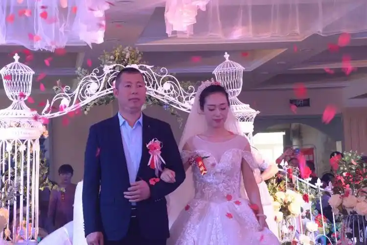 新娘李颖挽着爸爸坚实的臂膀缓缓走进婚场!