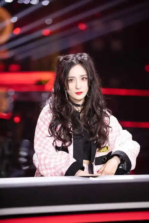 照片中,杨幂身穿粉色套装双马尾,她俏脸浓妆艳抹,猫咪妆容的幂姐,烈焰