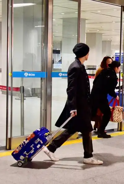 黄立行拉行李走出机场.徐静蕾黄立行黄立行雅痞有型.