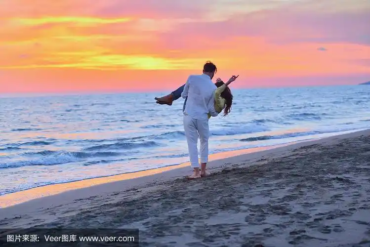 一对情侣在海滩上散步,拥抱相爱的情侣