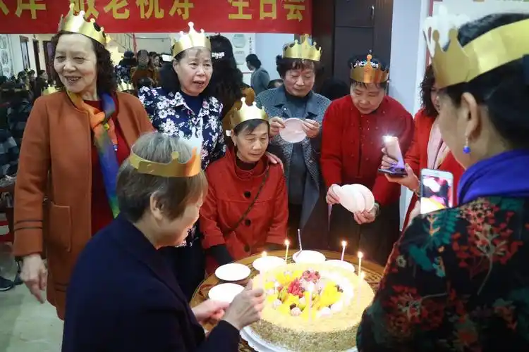 老人们一起合影留念,并分享了生日蛋糕.
