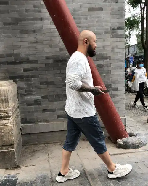 走在烟袋斜街的光头大胡子纹臂的年轻人