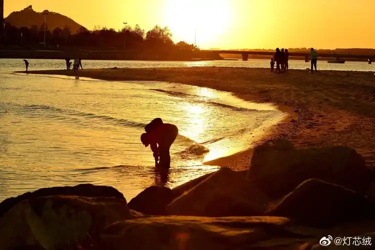 蓝天碧海白浪沙滩玩沙子捡贝壳太阳慢慢落山晚霞映照着海面