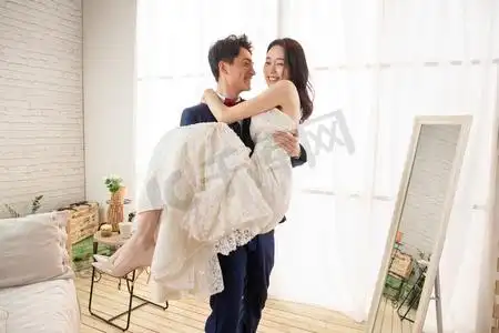 卧室里幸福的丈夫抱着妻子