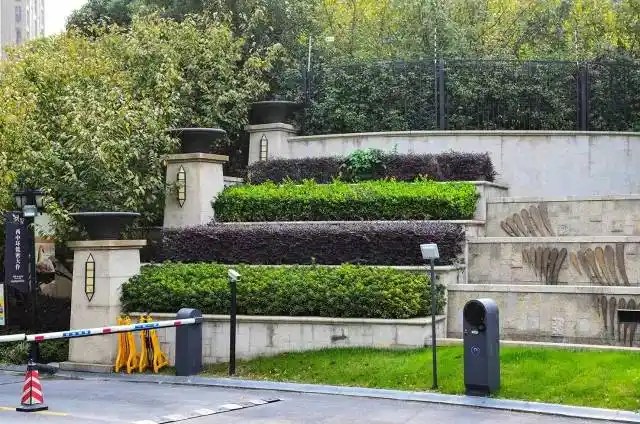 次入口一侧的挡土墙景观种植带,剪型花灌木,结合围墙栏杆,形成了高