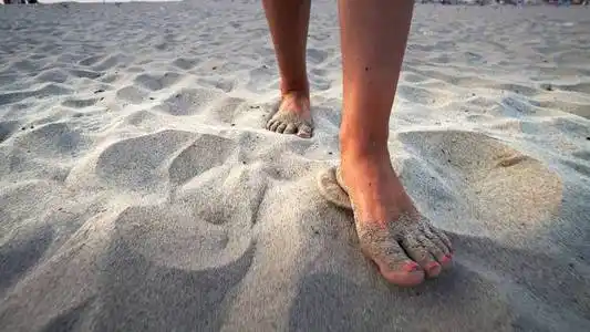 水疗护理女孩赤脚在人行道上踩粉笔脚印一个脚踩白毛巾的女人,特写.