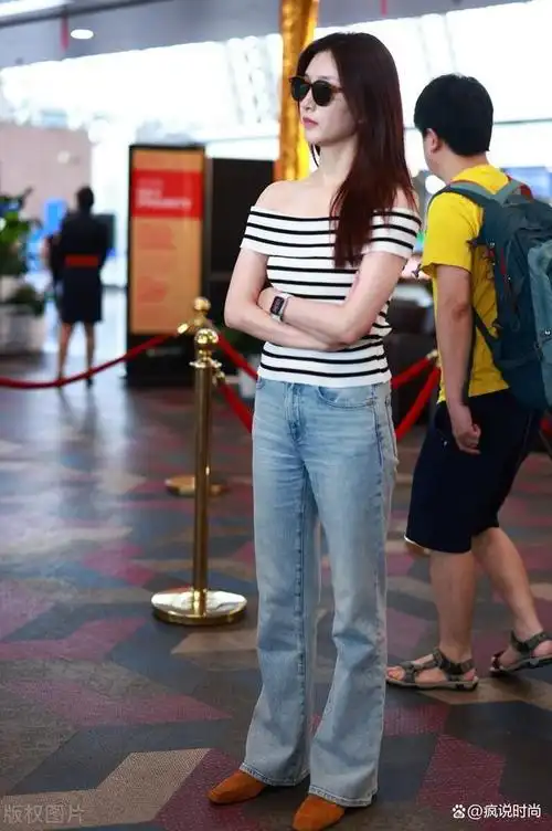 江疏影低调走机场,穿一字肩条纹衫搭牛仔裤,肩宽脸圆好真实