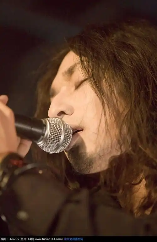 抱着麦克风演唱的长发男歌手