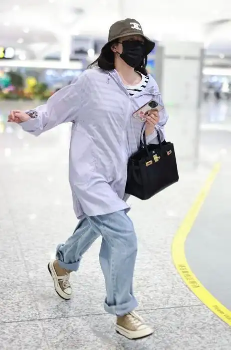 阚清子里面穿条纹t恤,外面搭配大码衬衣,下身穿复古风牛仔裤,脚踩高帮