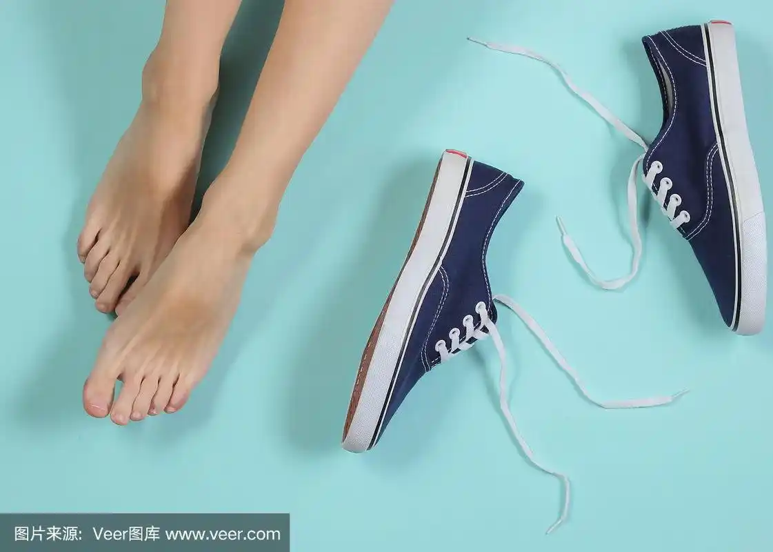 女人的光脚在蓝色的背景和运动鞋.俯视图