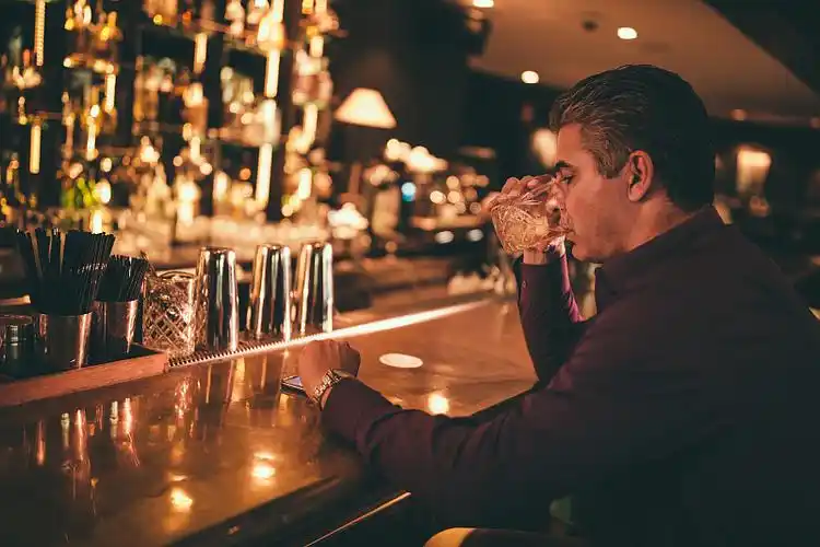 优雅成熟的男人在酒吧喝酒,看时间图片下载