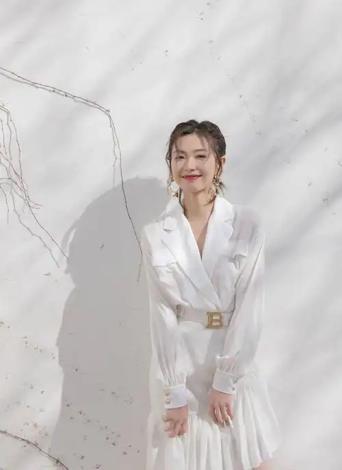 原创万茜手臂受伤走出机场热裤背心外加长外套走路带风