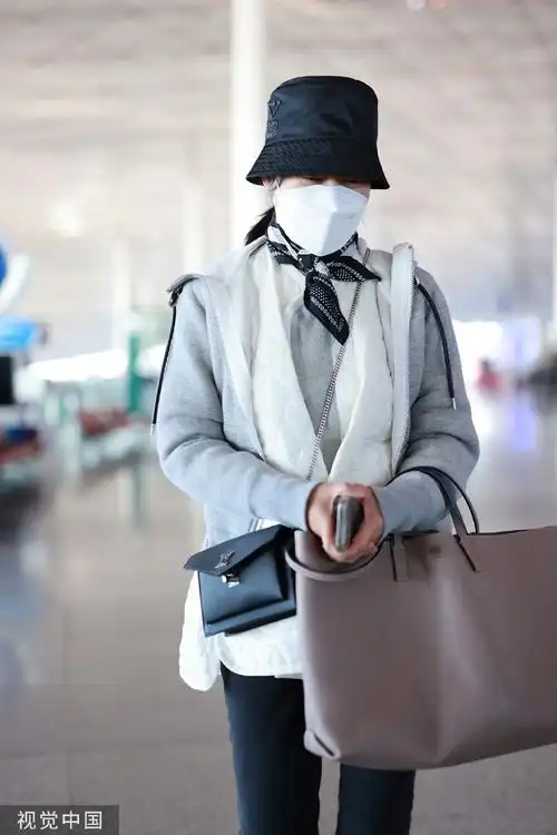 组图:闫妮戴渔夫帽现身机场 穿灰色外套休闲简约眼神温柔