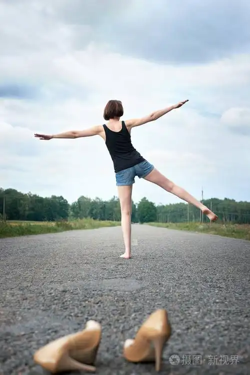 年轻的女孩赤脚走在路上,她把鞋子落在路上,忘记了夏天和旅行的概念