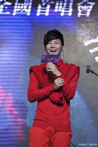 炎亚纶在活动中身穿红衣,笑容可掬气质出众