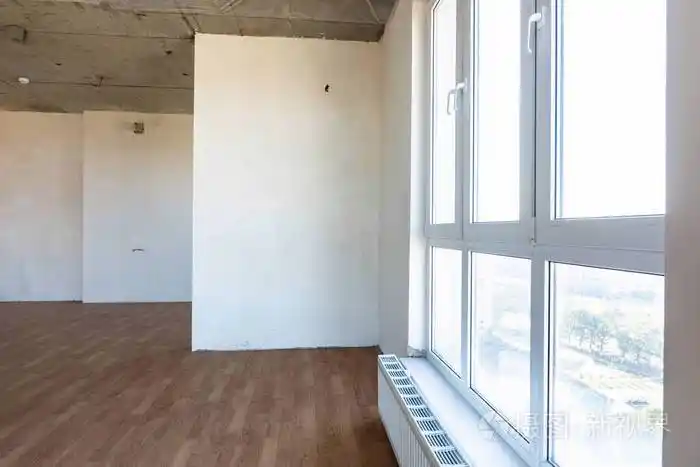 一座新大楼的空房间里有一扇大的彩色玻璃窗和电池