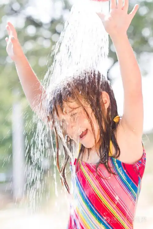 快乐的小女孩享受在夏季的一天,玩水