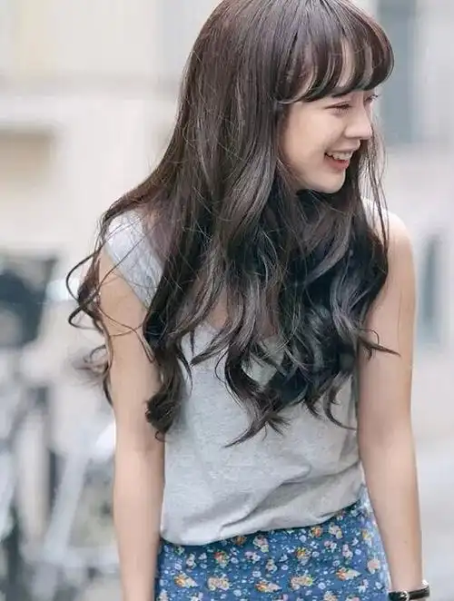 长发波浪卷带着纯真的黑色发丝,而留出空气齐刘海发型就能很好的去