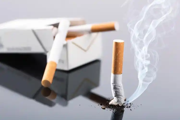 医生的手显示禁用的姿态和拿着香烟禁止吸烟标志孤立在白色背景女人女