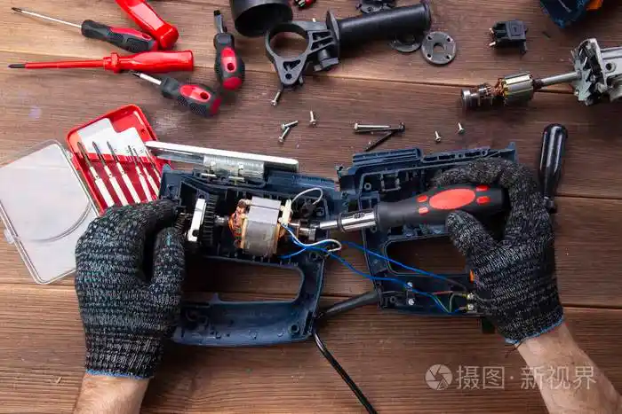 主人修理一个坏了的电器钻头木桌上的切割机电动工具修理厂