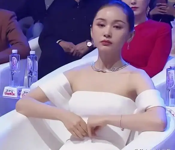 王子文坐在沙发上,助理跪着给她穿鞋,那双鞋本来挺好穿的,但王子文不