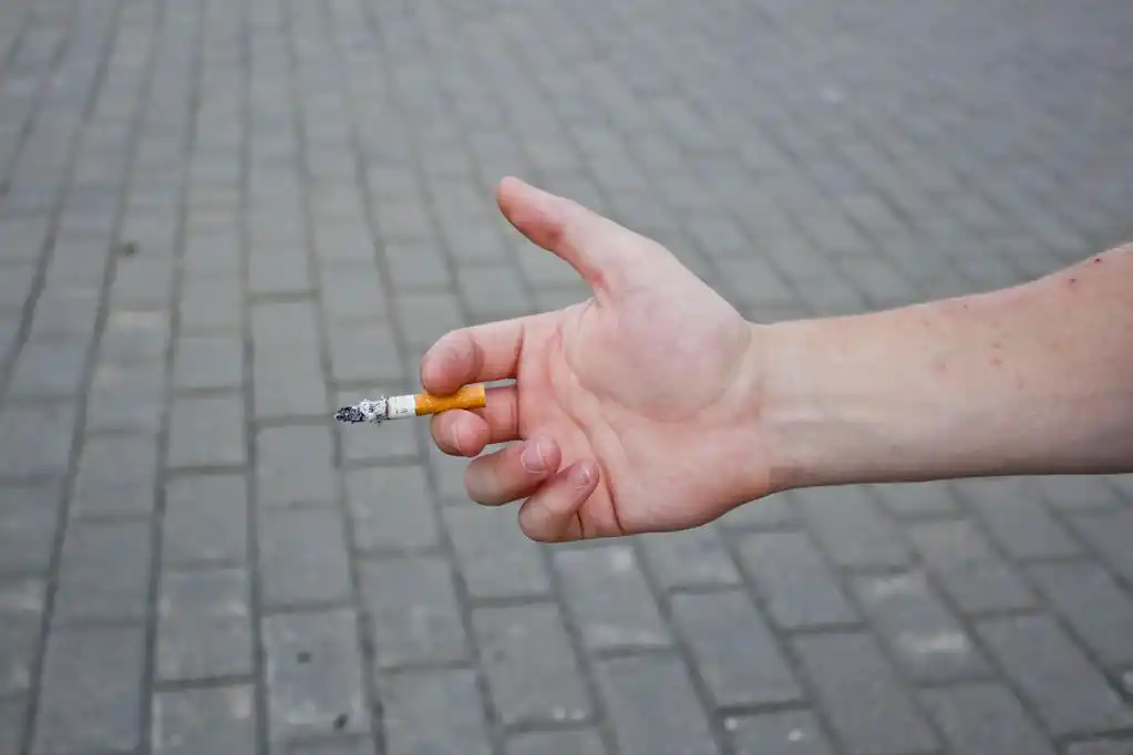 手用香烟,手带烟灰色背景