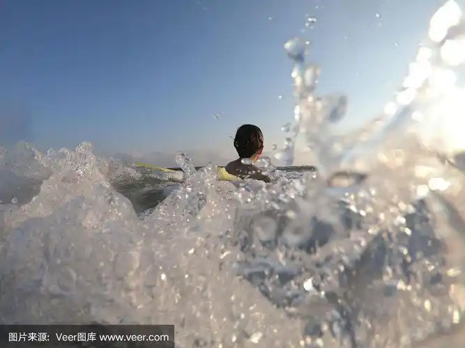 快乐的男孩在海里游泳溅起水花