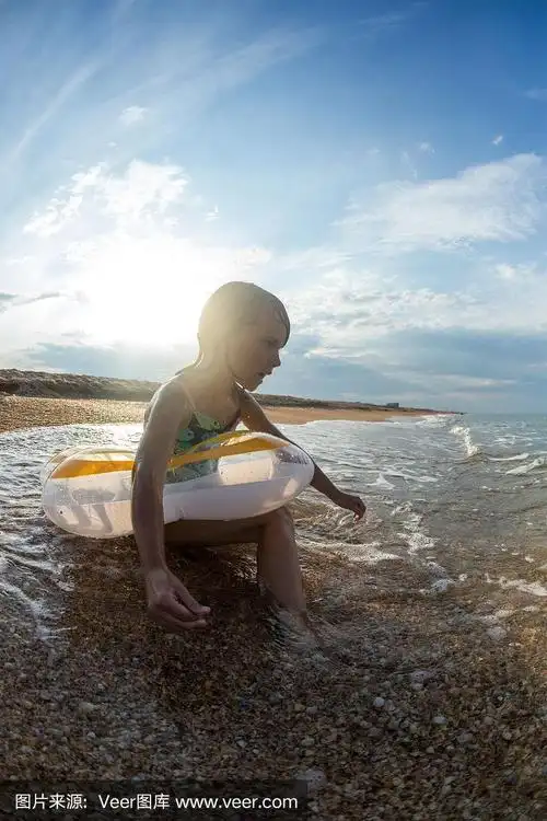 肖像,快乐的小女孩游泳在一个充气圈的海上,广角景观