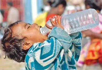 一名幸存的儿童在难民营中喝水.