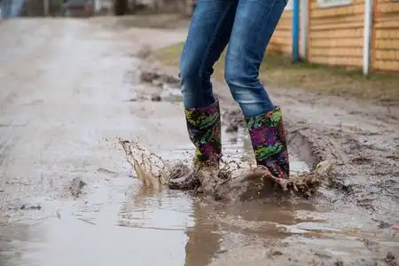 女雨靴雨靴跳跃的女人照片