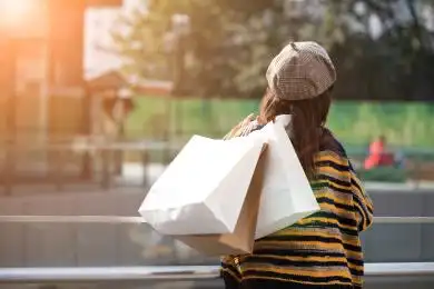 在商场逛街购物的年轻女性背影